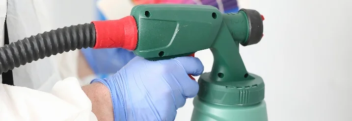 Person hält Farbsprühgerät